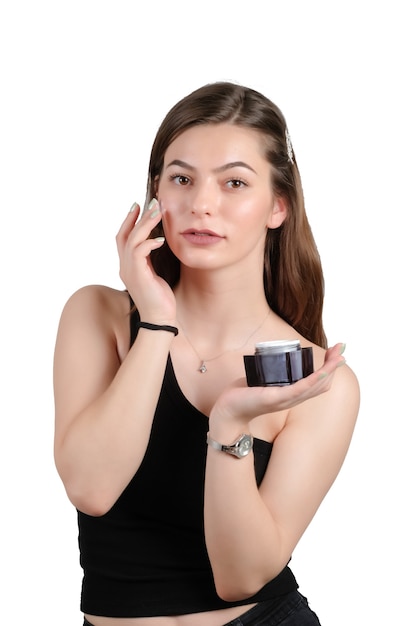 Close up beauty portrait of a laughing beautiful woman applying face cream and staring isolated