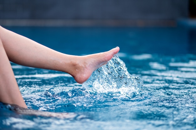 Close-up beeld van benen en linkervoet schoppen en opspattend water in het zwembad