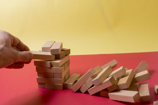 Close-up beeld van een hand die Jenga of Tumble toren houten blok spel houdt en speelt