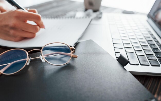 Close-up beeld van een jonge vrouwelijke freelancer die overdag binnen in het kantoor werkt