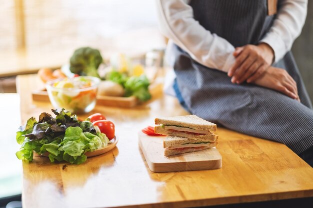 Close-up beeld van een vrouwelijke chef-kok klaar met het koken van volkoren sandwich in de keuken