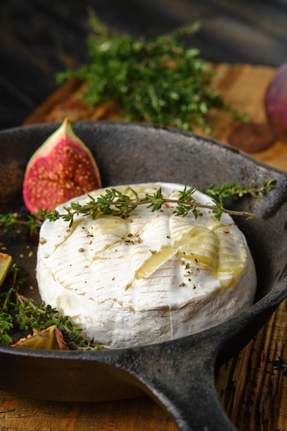 Close-up beeld van gebakken camembert kaas en vijgen klaar voor bakken op koekenpan