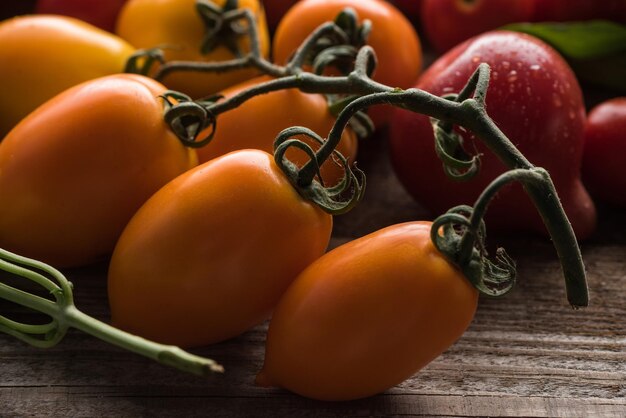 Foto close-up beeld van gele tomaten in de buurt van rode tomaten op een houten tafel