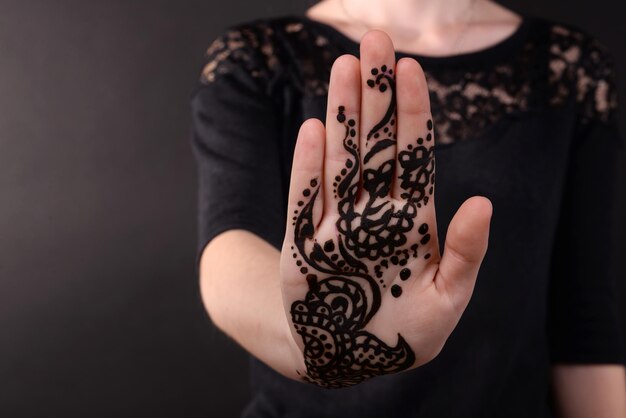 Close-up beeld van henna op vrouwelijke hand op donkere achtergrond