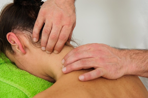 Close-up beeld van mannelijke masseur masseren rug- en schouderbladen van vrouw liggend op massagetafel in spa salon mooie jonge vrouw met perfecte huid krijgen ontspannende massage