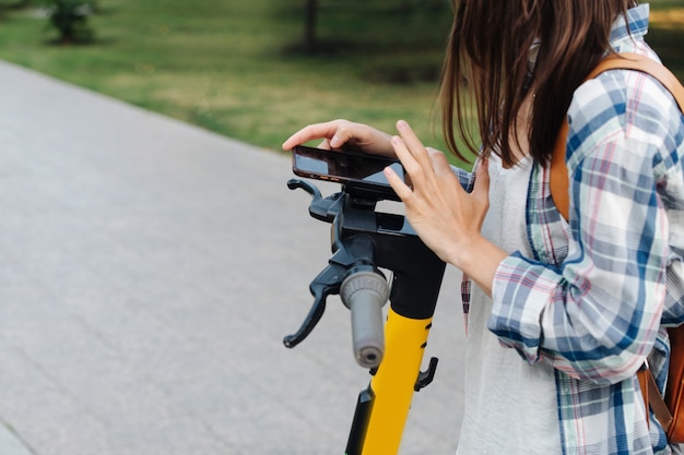 Close-up beeld van vrouw handen betalen voor haar elektrische scooter met een telefoon app