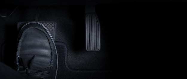 Close-up beelden van man autorijden door het gaspedaal en het rempedaal in te drukken met de zwarte leren schoen van de rechtervoet en zwarte jeansbroek. in de Japanse auto.