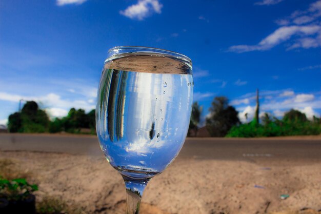 Close-up of beer glass against blue sky