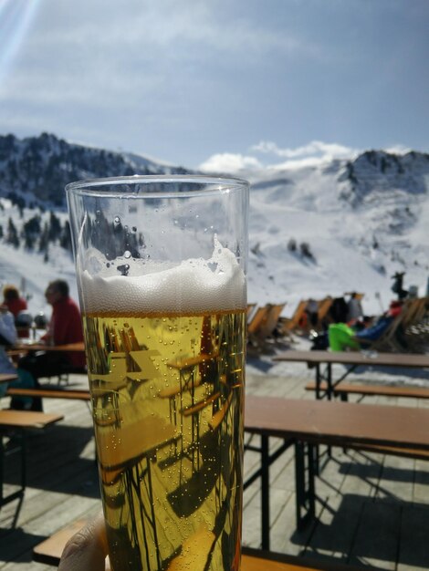 Photo close-up of beer in glass at sidewalk cafe on mountain