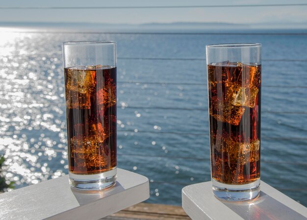 Photo close-up of beer on table against sea