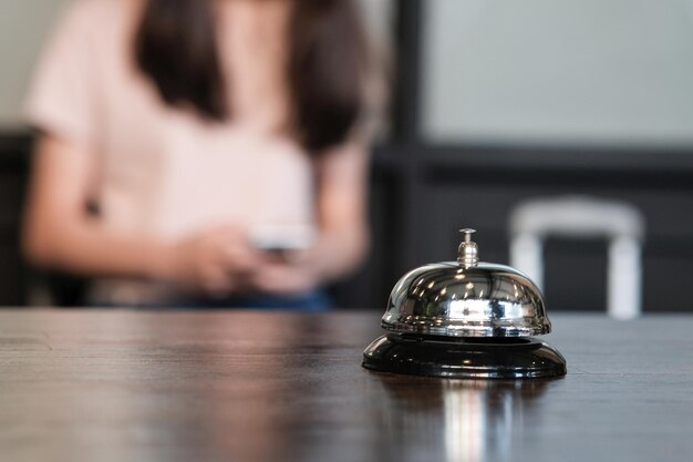 Close-up of bell on table with woman in background