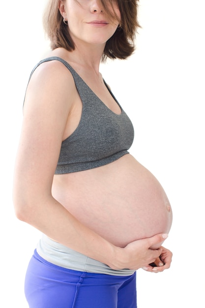 Close-up belly of a pregnant woman in sportswear