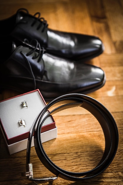 Foto close-up di cravatte e gemelli di manetto da scarpe su tavolo