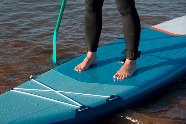 Foto close-up benen staande op paddleboard