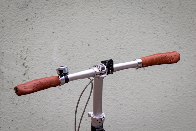 Foto close-up di una bicicletta sulla strada contro un muro