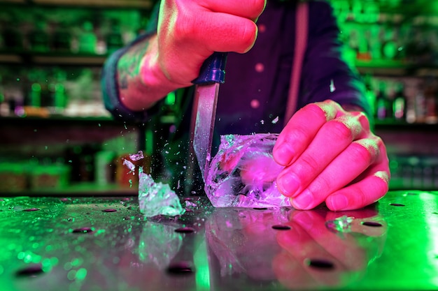 Primo piano grande pezzo di ghiaccio che si scioglie sul bancone del bar in fiamme, preparazione per un cocktail