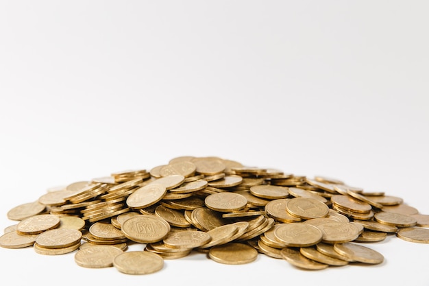 Close up of big pile of golden coins isolated on white background. Concept of money business growth gain success earnings. Copy space for advertisement. With place for text.