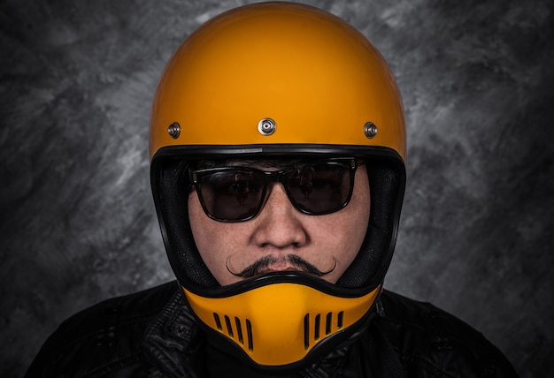 Close up of biker man in motorcycle helmet and leather jacket 