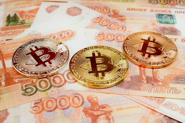 Close-up of Bitcoin coins on 5000 Russian rubles banknote. Crypto currency BTC.