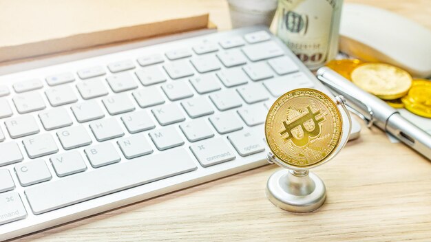 Close-up of bitcoin and keyboard on table