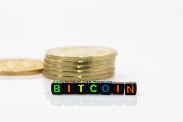 Close-up of bitcoin with alphabet blocks against white background