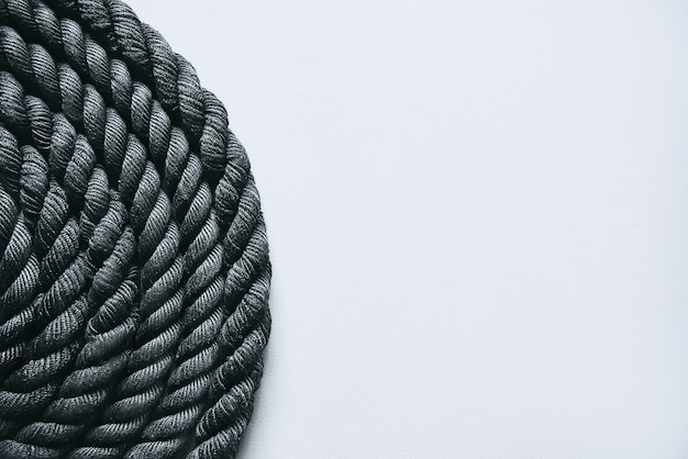 Close up of black battle rope on a gray backgound. Sport and fitness equipment