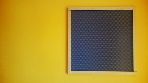 Photo close-up of black board on yellow wall