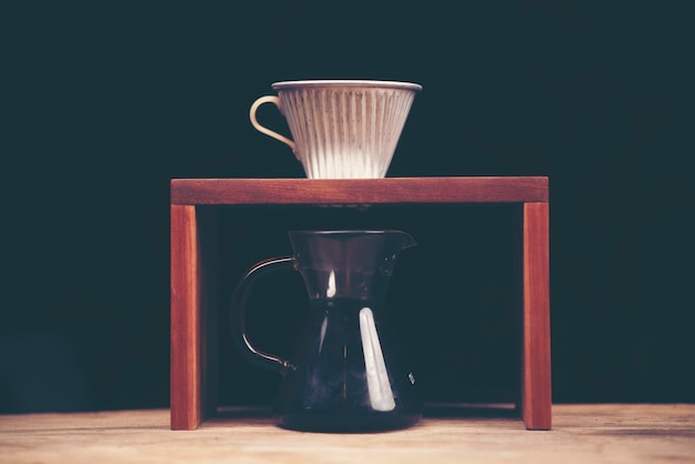 Клоуз-ап черного кофе в банке на столе на черном фоне