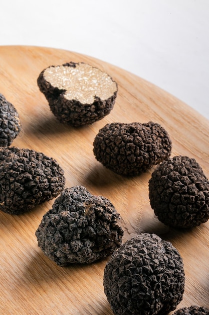 Close up of black truffle mushroom on wooden plate isolated