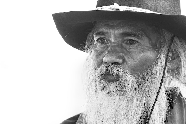 Close-up black and white photo of an old man in a cowboy costume