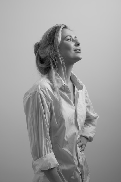 Close up black white portrait of sexy blond young woman in white mens shirt posing at home, happy girl smiling and laughing studio shot