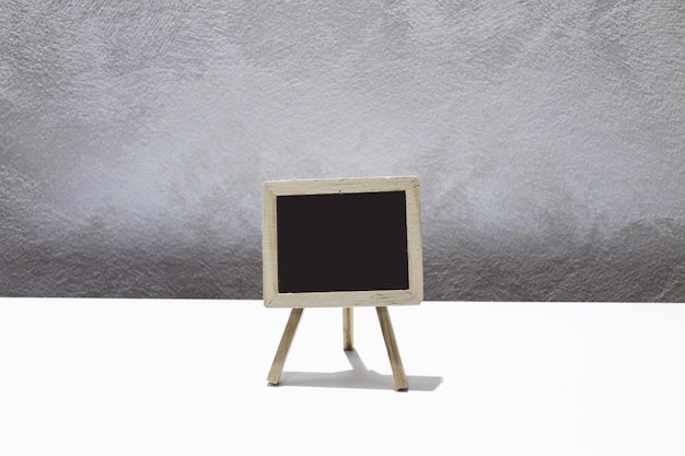 Close-up of blackboard on table against wall