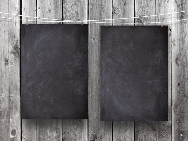 Photo close-up of blackboards hanging against wooden wall