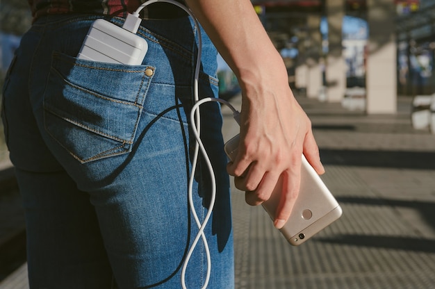 手にパワーバンクを持って空白の携帯電話でクローズアップ