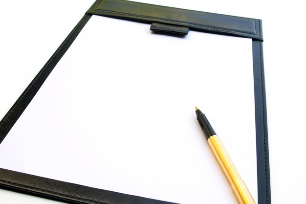 Photo close-up of blank paper and pen over white background