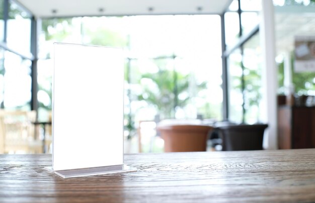 Photo close-up of blank placard on wooden table at restaurant