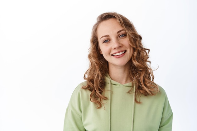 Photo close up of blond beautiful woman with perfect smile natural light make up looking hopeful and happy at camera white background