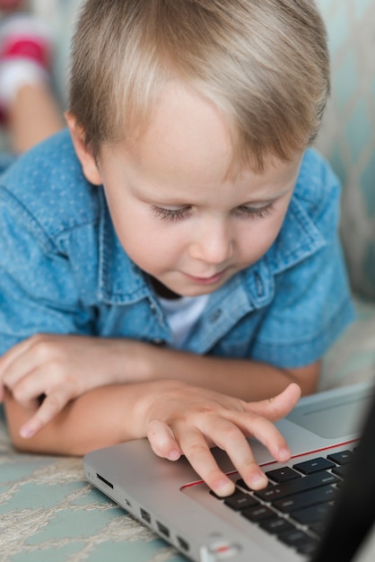 Foto primo piano del ragazzo biondo che per mezzo del computer portatile