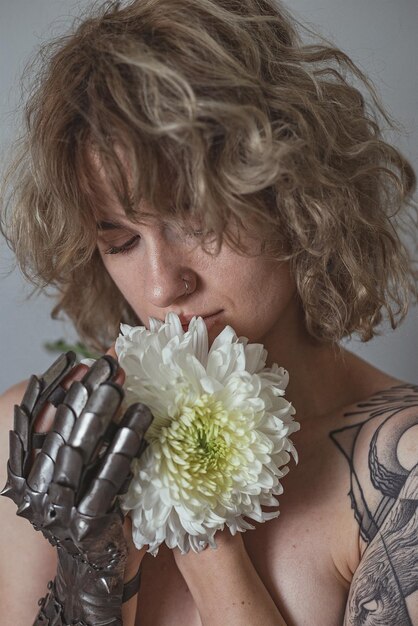 Close up blonde woman with dahlia flower in studio portrait picture