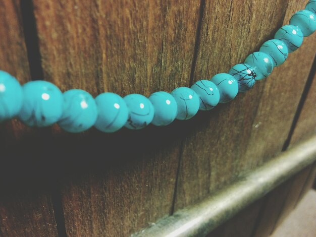 Photo close-up of blue bead string on wood