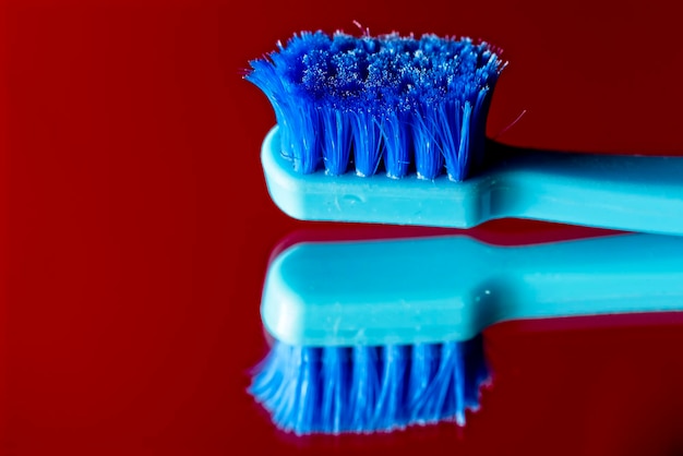 Close-up of blue brush over red background