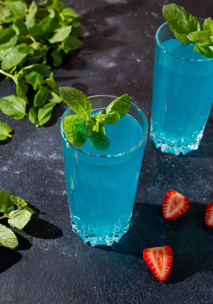 close up blue cocktail with mint on a dark background