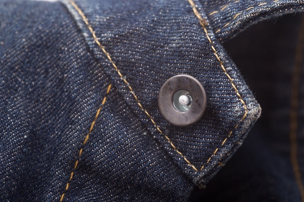 Close-up blue denim with pocket and button.