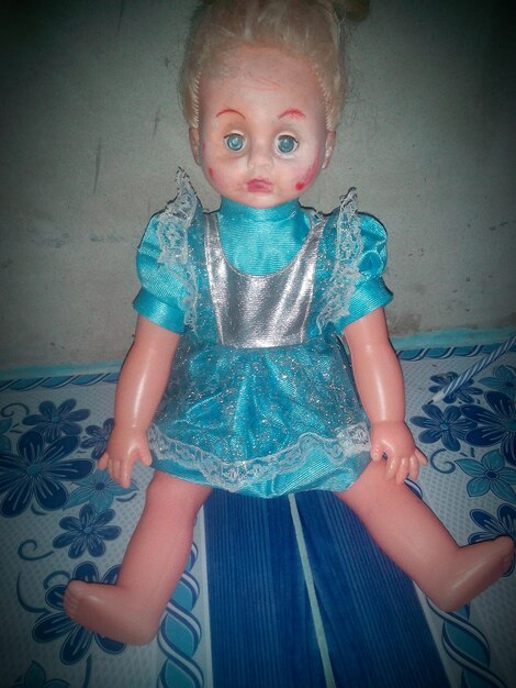 Close-up of blue doll on bed at homer