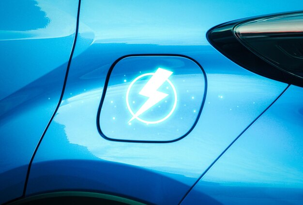 자동차 쪽 EV 전기 자동차 기술 개념의 배터리 충전기 소켓 뚜껑에 번개 충전기 기호가 있는 파란색 EV 전기 자동차를 닫습니다.