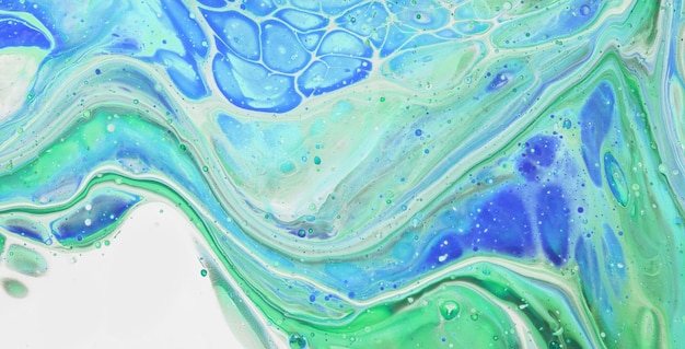 A close up of a blue and green liquid painting