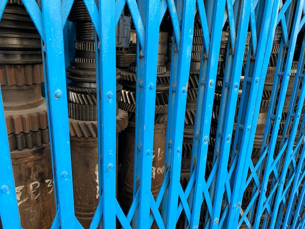 Close-up of blue metallic sliding gate structure against building