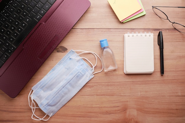 Close up of blue surgical masks and hand sanitizer on table