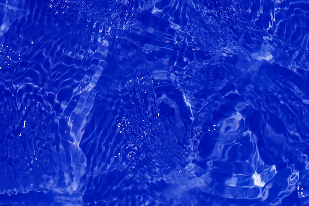 잔물결과 물이라는 단어가 있는 푸른 수면의 클로즈업