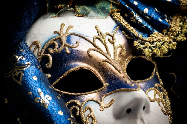 Close up of a blue with gold elegant traditional venetian mask over white background